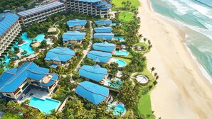 Vista aèria d'un complex turístic amb diversos edificis, piscines i una platja.