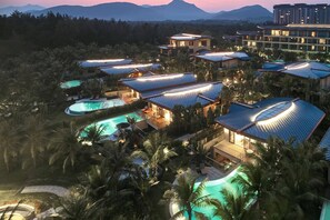 Ein Resort mit mehreren Gebäuden, einem Schwimmbad und üppiger Bepflanzung.
