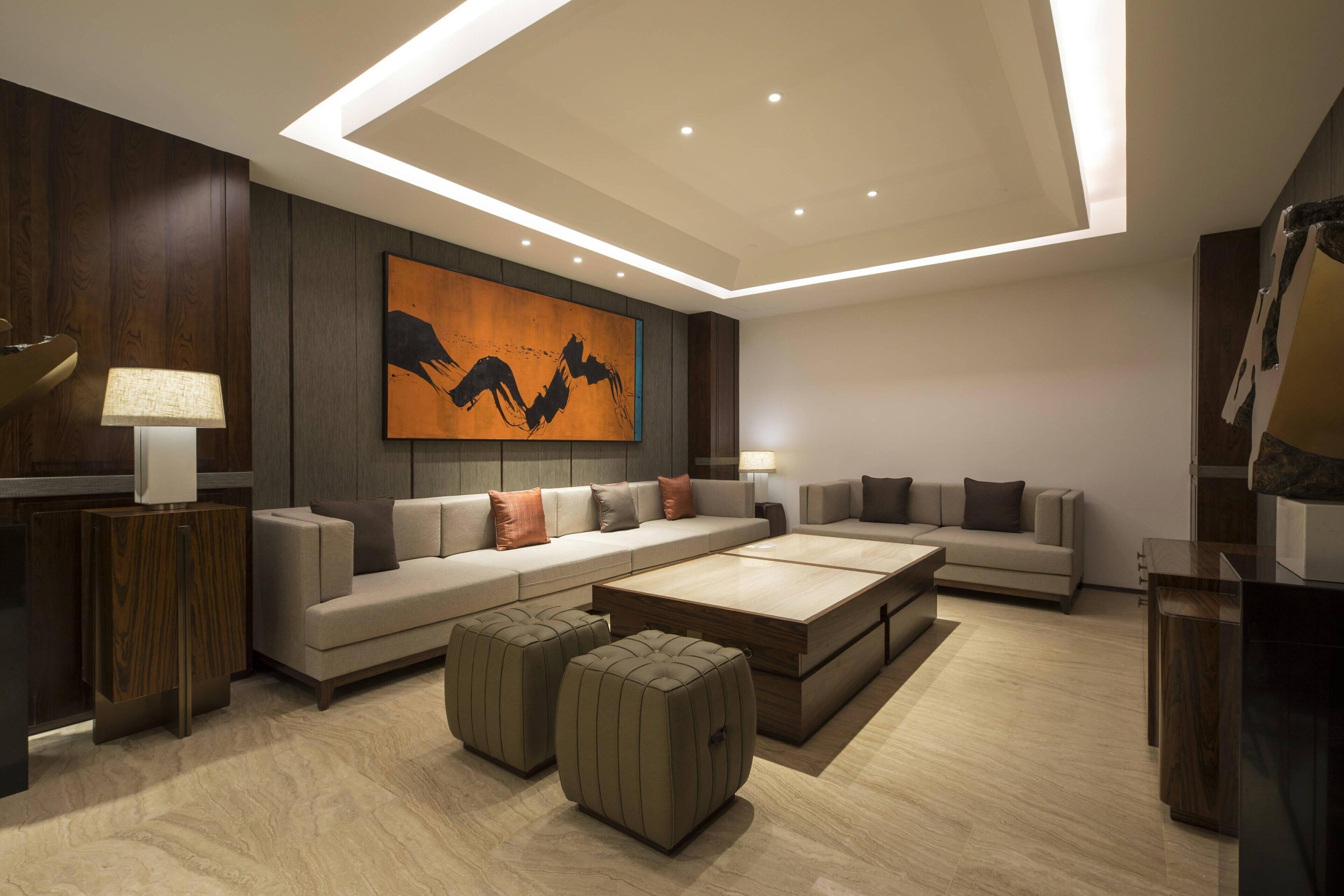 A modern living room with a sectional sofa, ottomans, and a coffee table.
