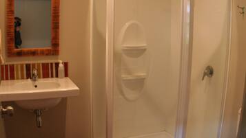 Une salle de bain avec une douche, un lavabo et des toilettes.