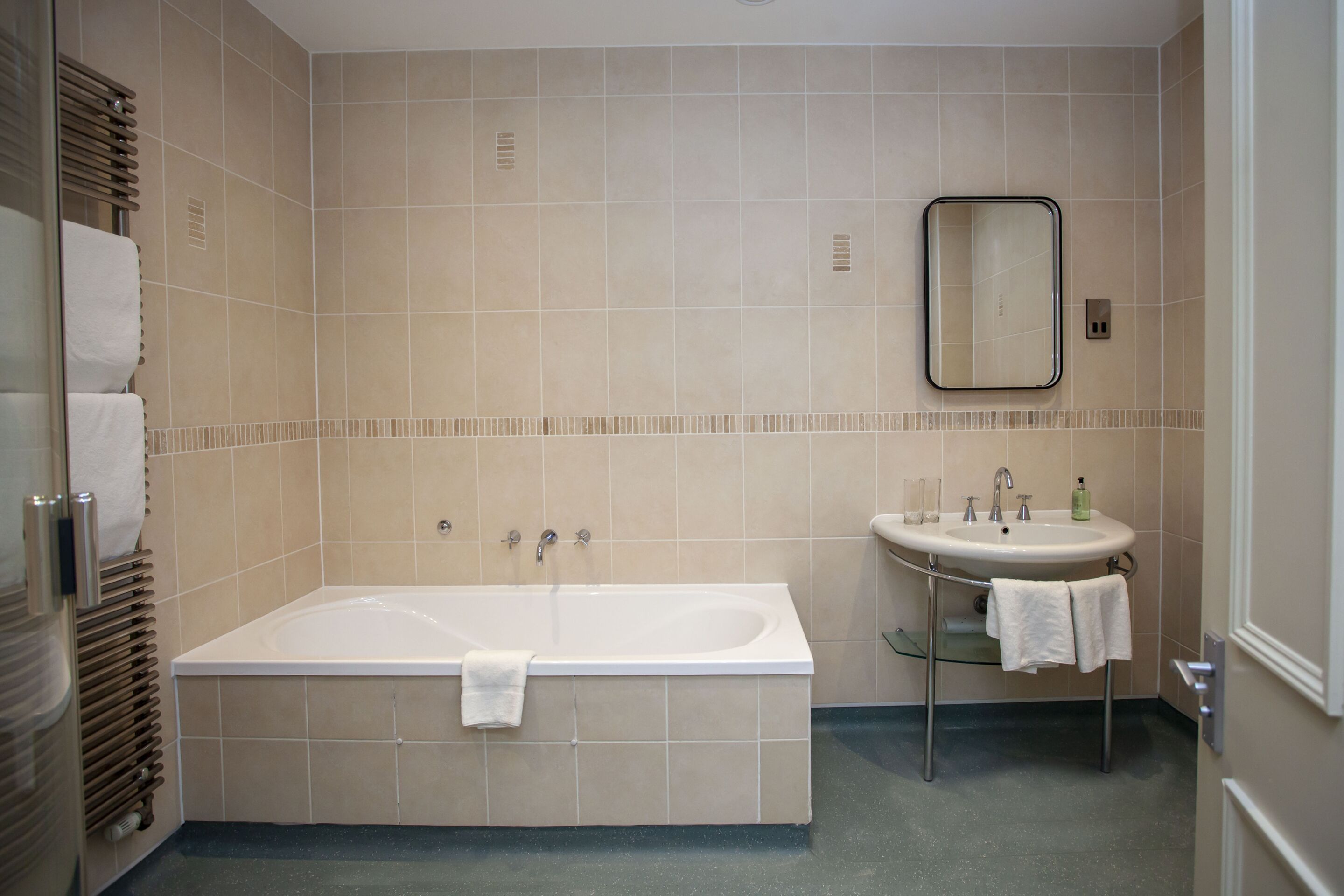 Een moderne badkamer met een bad, een wastafel en een spiegel.