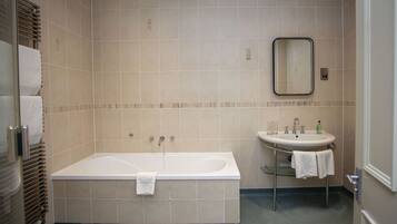 Een moderne badkamer met een bad, een wastafel en een spiegel.