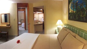 A hotel room with a bed, a desk, a chair, a bathroom, and a painting on the wall. - Coral Ixtapa (Ixtapa)
