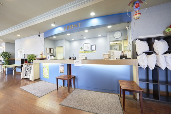 A reception desk with a blue accent, a clock, and a sign indicating a 24-hour service. - Hotel Select Inn Aomori (Aomori)