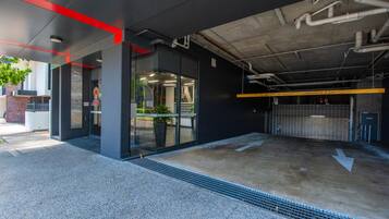 Eine moderne Tiefgarage mit Höhenbeschränkungshinweis, einem Metallgittereingang und einem Betonboden.