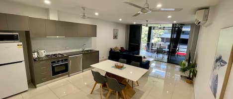 Una cocina moderna con comedor, ventilador de techo y vistas al exterior.