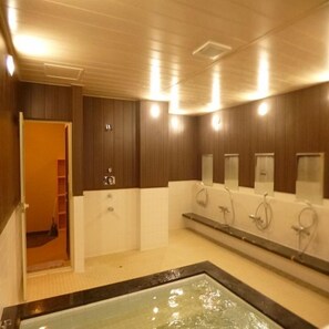 Un baño con una bañera grande, paredes de madera y un espejo sobre el lavamanos.