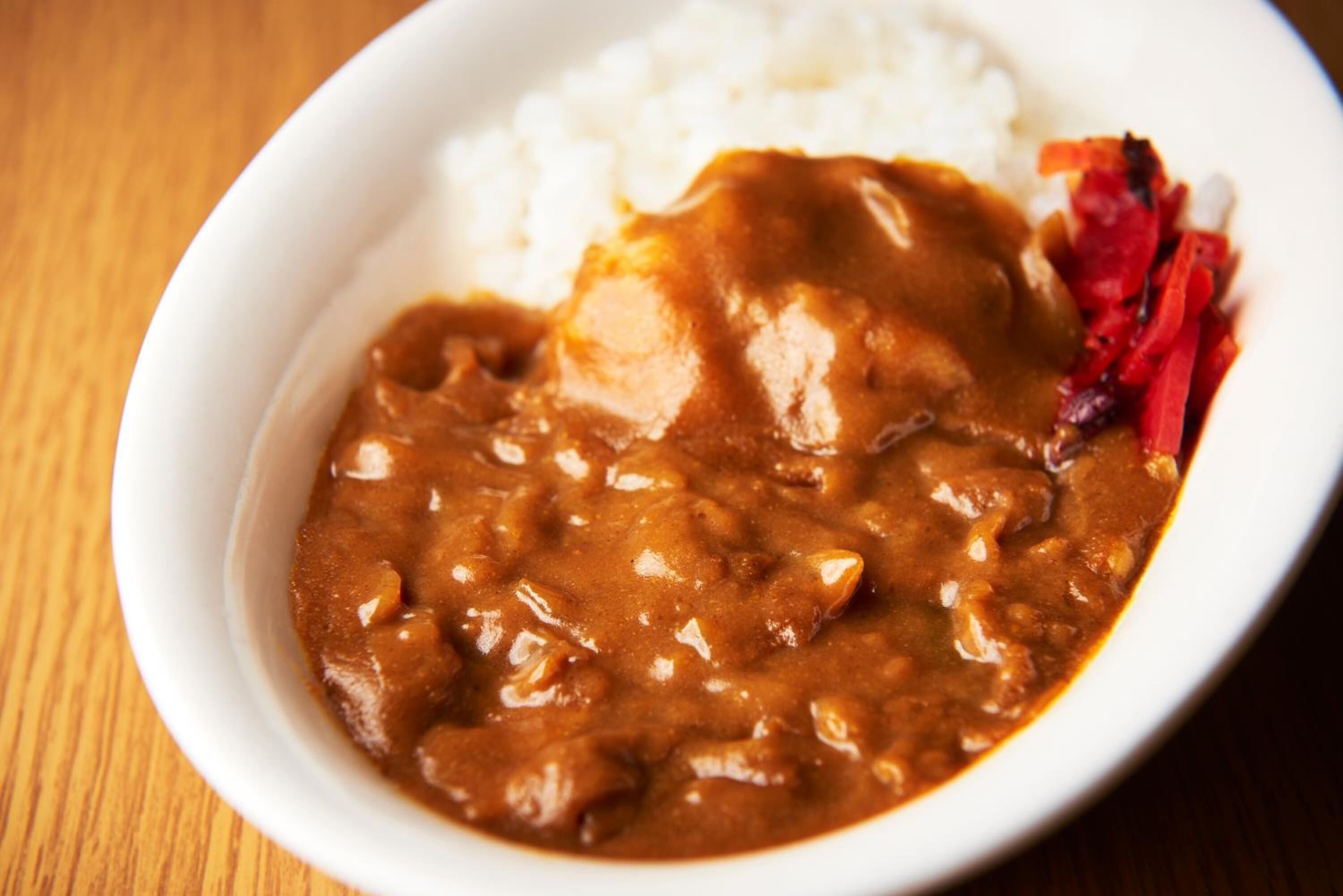 A bowl of curry with rice and vegetables.