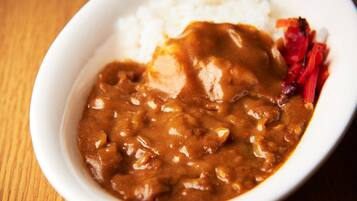 A bowl of curry with rice and vegetables.