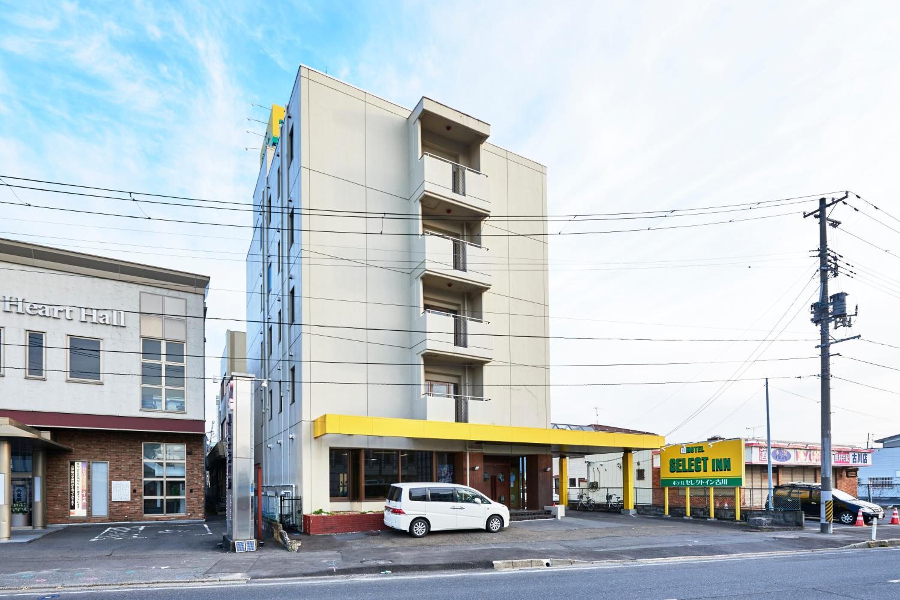 A building with a yellow awning and a sign for 'Select Inn'.