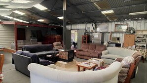 A spacious living room with multiple sofas and a fireplace. - Inglewood Motel and Caravan Park (Inglewood)