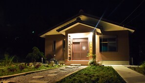 A house with a wooden door and a small garden in front.