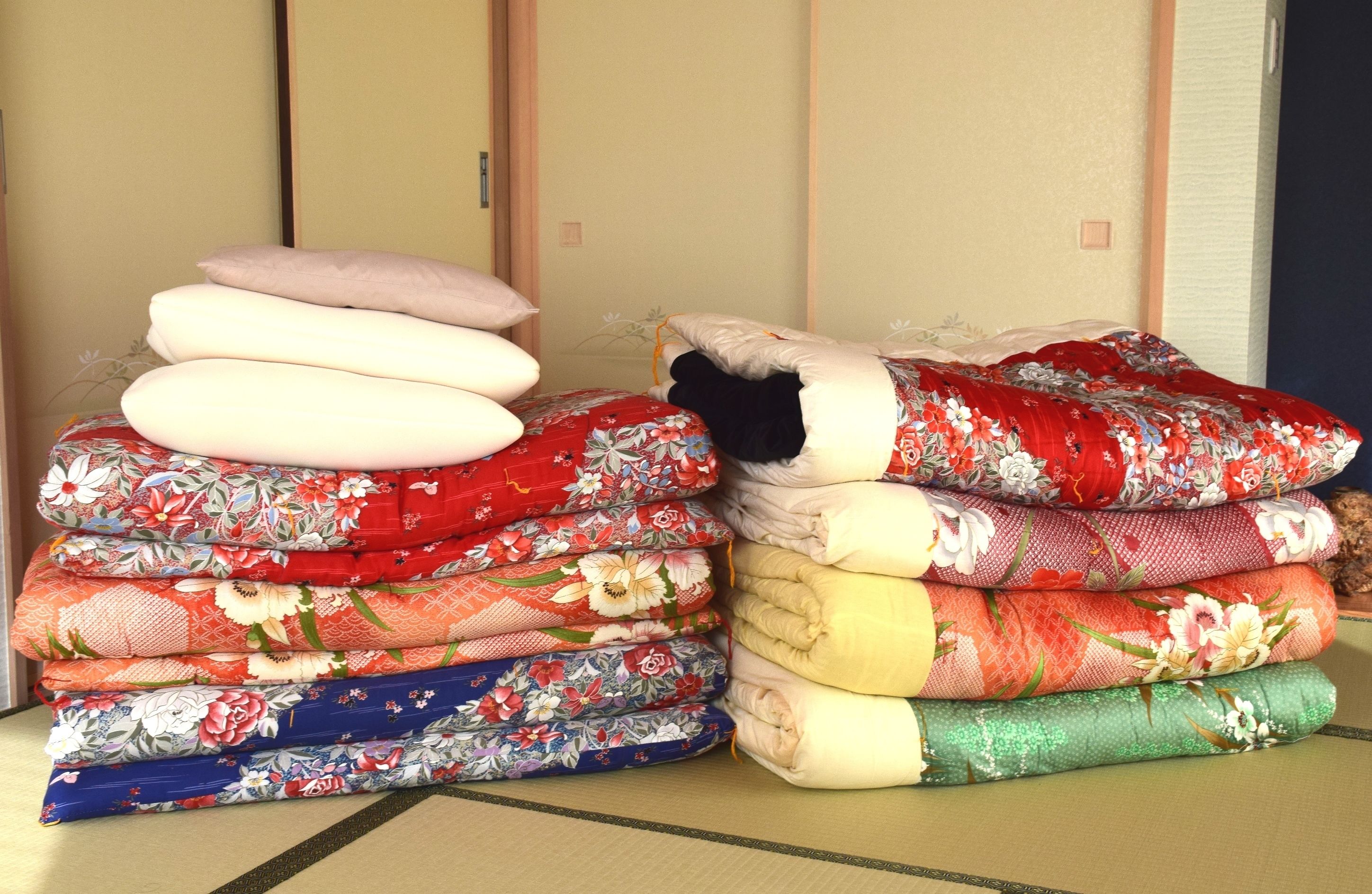 A stack of neatly folded bedding with floral patterns.
