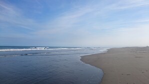 Une plage avec des vagues et un ciel dégagé.