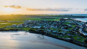 An aerial view of a coastal town with houses, roads, and a beach.