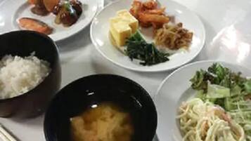 A table with various dishes including rice, soup, and plates with different foods.