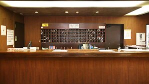 A reception desk with a wooden counter and a wall-mounted shoe rack. - Hotel Select Inn Utsunomiya (Utsunomiya)