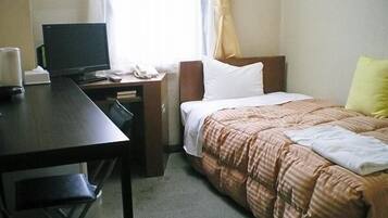 Una camera d'albergo con un letto, una scrivania con un computer e una sedia.