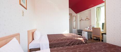 Une chambre d’hôtel avec deux lits, un bureau et une chaise.
