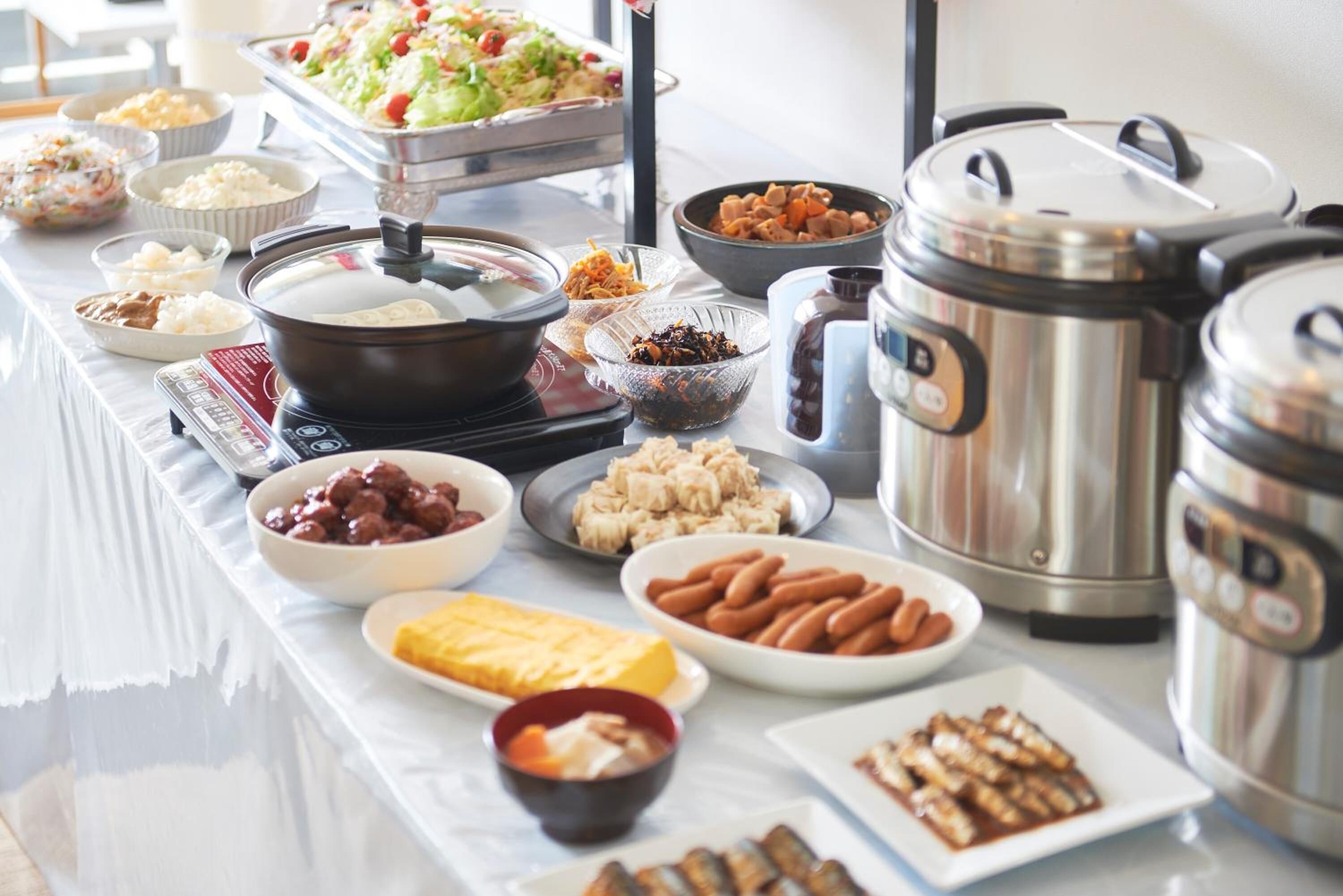 Una mesa de buffet con diversos platos y equipo de cocina.