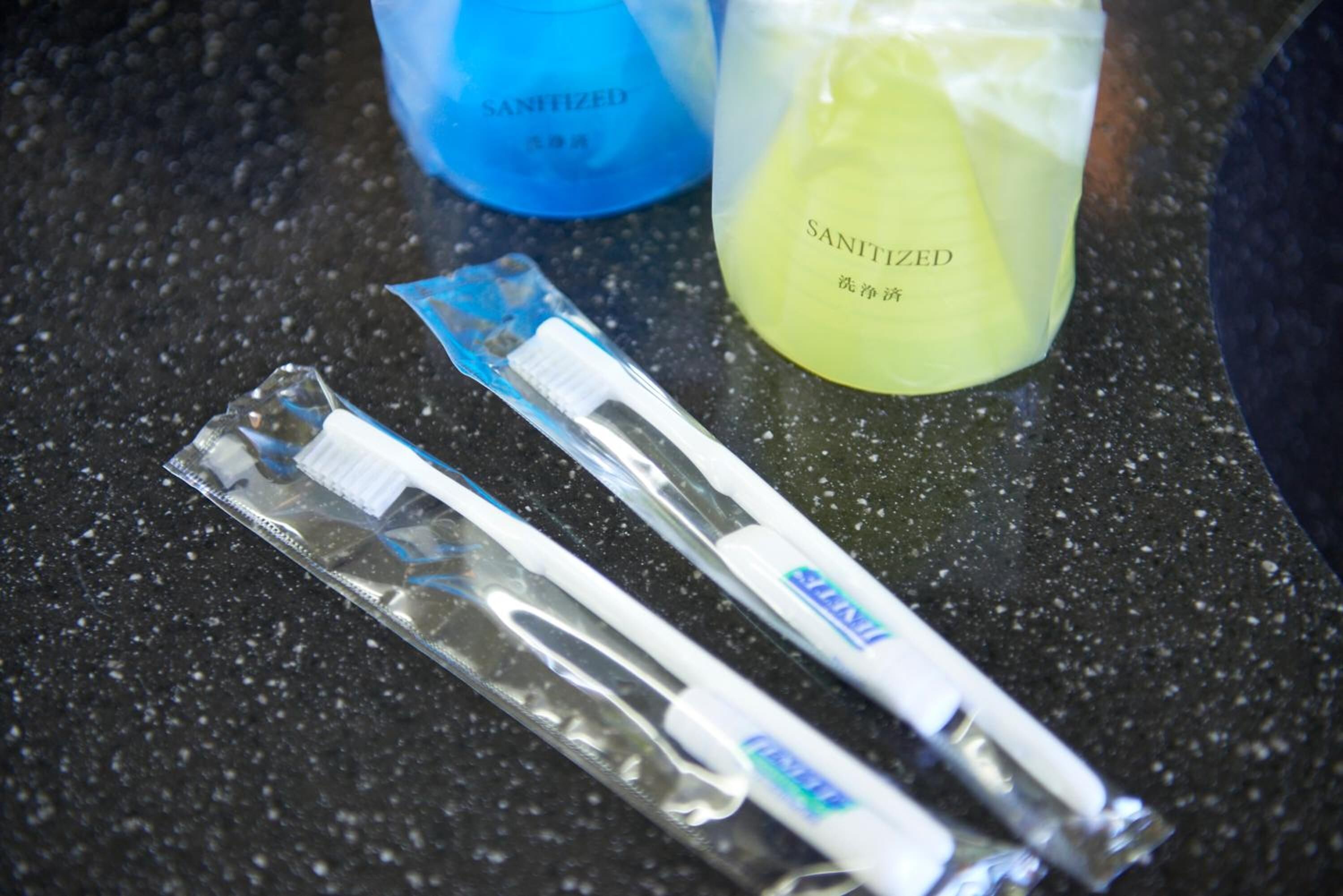 Two toothbrushes and two bottles of mouthwash on a countertop.