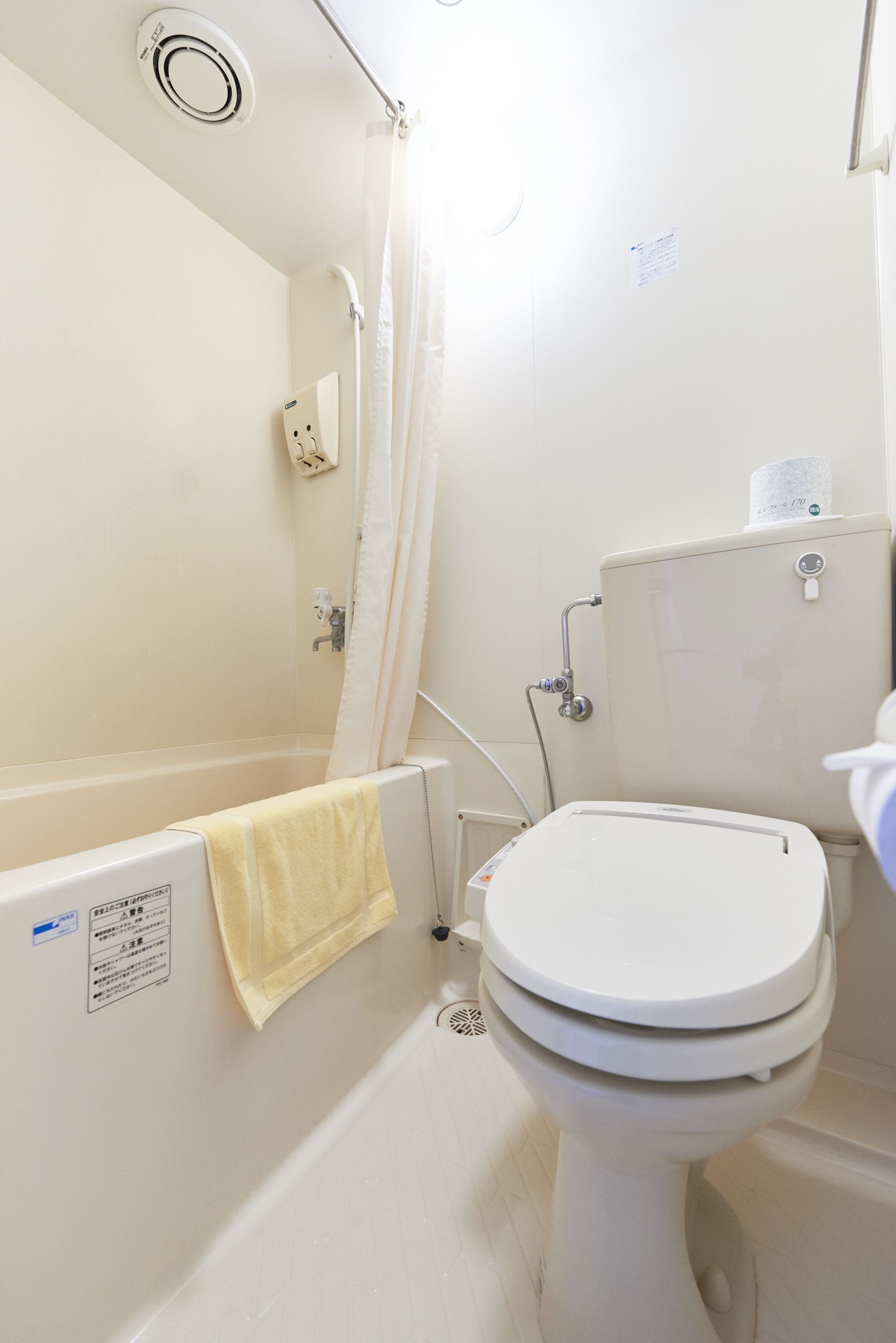 A bathroom with a bathtub, toilet, and shower.