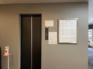 An elevator with a sign listing guest room numbers and a notice about COVID-19 precautions. - Hotel Select Inn Saitama Moroyama (Moroyama)