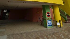 A hotel entrance with a yellow and green facade, a sign reading "Select Hotels Group," and a bicycle parked outside. - Hotel Select Inn Saitama Moroyama (Moroyama)