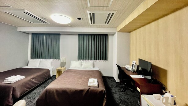A hotel room with two beds, a desk, a chair, a TV, and a desk lamp. - Hotel Select Inn Saitama Moroyama (Moroyama)