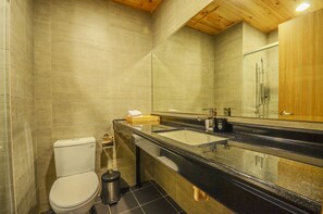 A modern bathroom with a toilet, sink, and mirror. - Calamari Hostel (Magong)