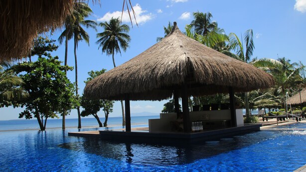 A thatched-roof structure over a pool with a view of the ocean. - Hijo Resorts Davao (Tagum)