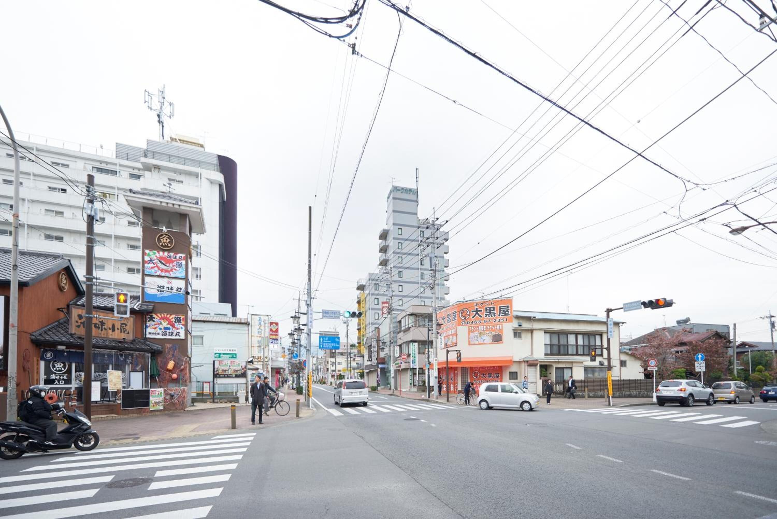 A street intersection with buildings, a crosswalk, and vehicles.