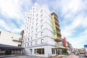 Un hôtel à plusieurs étages, reconnaissable à son grand panneau jaune sur le côté.