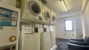 A laundry room with multiple washing machines and dryers, a window, and a door. - Hotel Select Inn Isehara (Isehara)