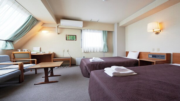 A hotel room with two beds, a desk, a chair, a small table, and a window with curtains. - Hotel Select Inn Yaizu Ekimae (Yaizu)