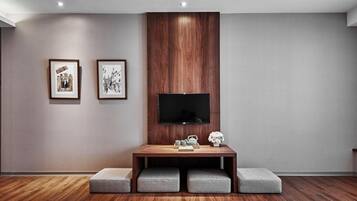 Una sala de estar moderna con un mueble de televisión de madera, un televisor de pantalla plana y dos cuadros en la pared.