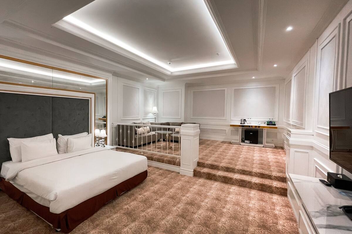 Une chambre d’hôtel moderne équipée d’un grand lit, d’un bureau, d’une chaise et d’un téléviseur.