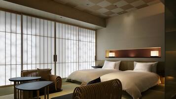 A modern hotel room with a large sliding shoji screen, a bed with two pillows, a bedside table, and a small sofa.