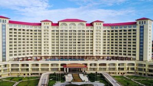 Un gran hotel con varios pisos, un patio central y una fuente.