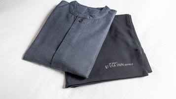 A folded garment with a visible button and a logo on the sleeve.
