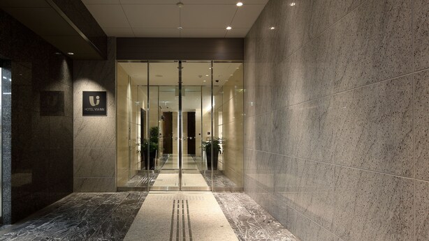 A modern hotel lobby with a marble floor, glass doors, and a sign indicating the hotel name. - JR WEST GROUP VIA INN NAGOYA SHINKANSENGUCHI (Nagoya)