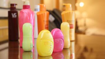 Diversos productos para el cuidado del cabello sobre una superficie reflectante.