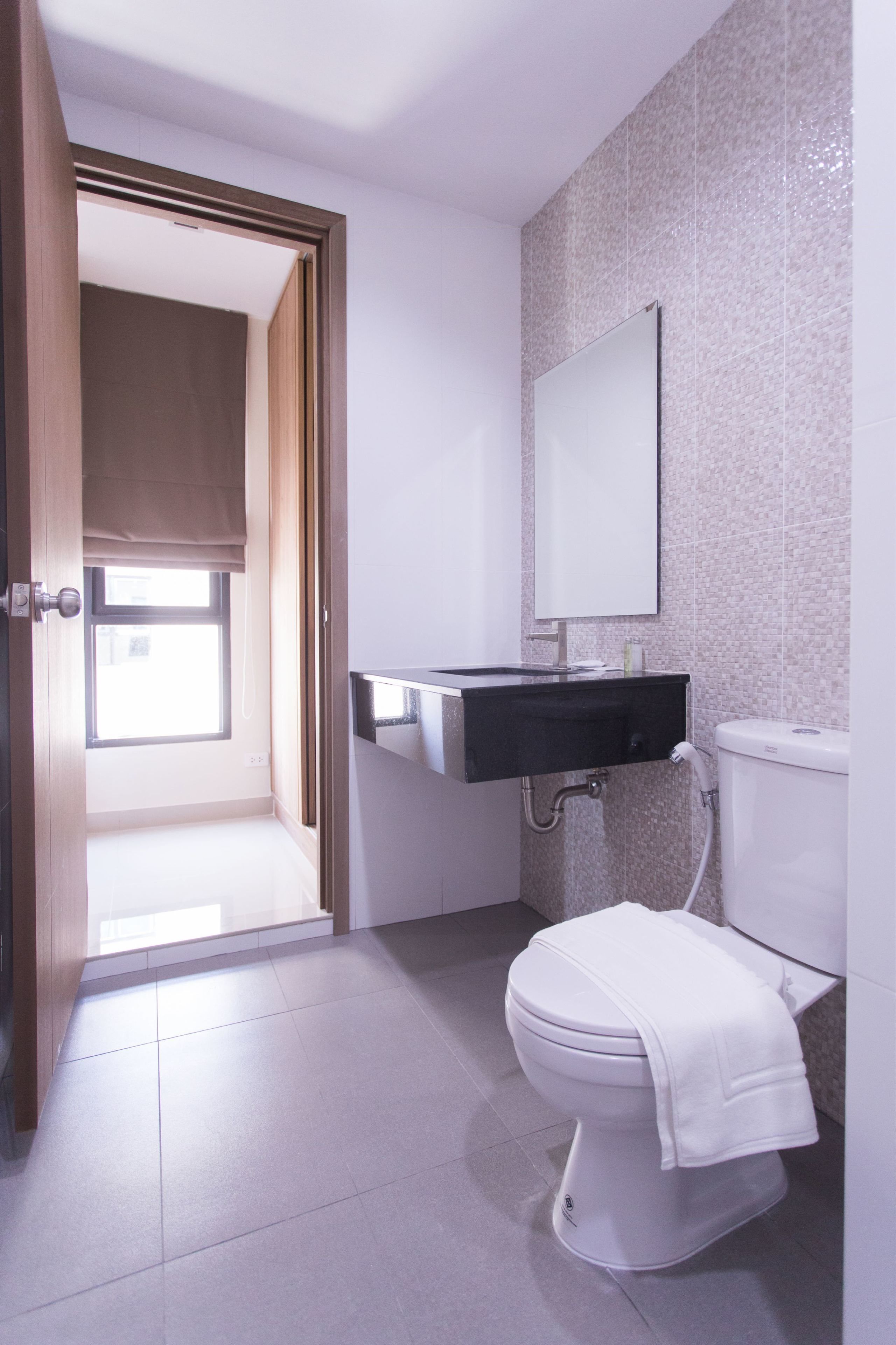 A modern bathroom with a toilet, a sink, and a mirror.