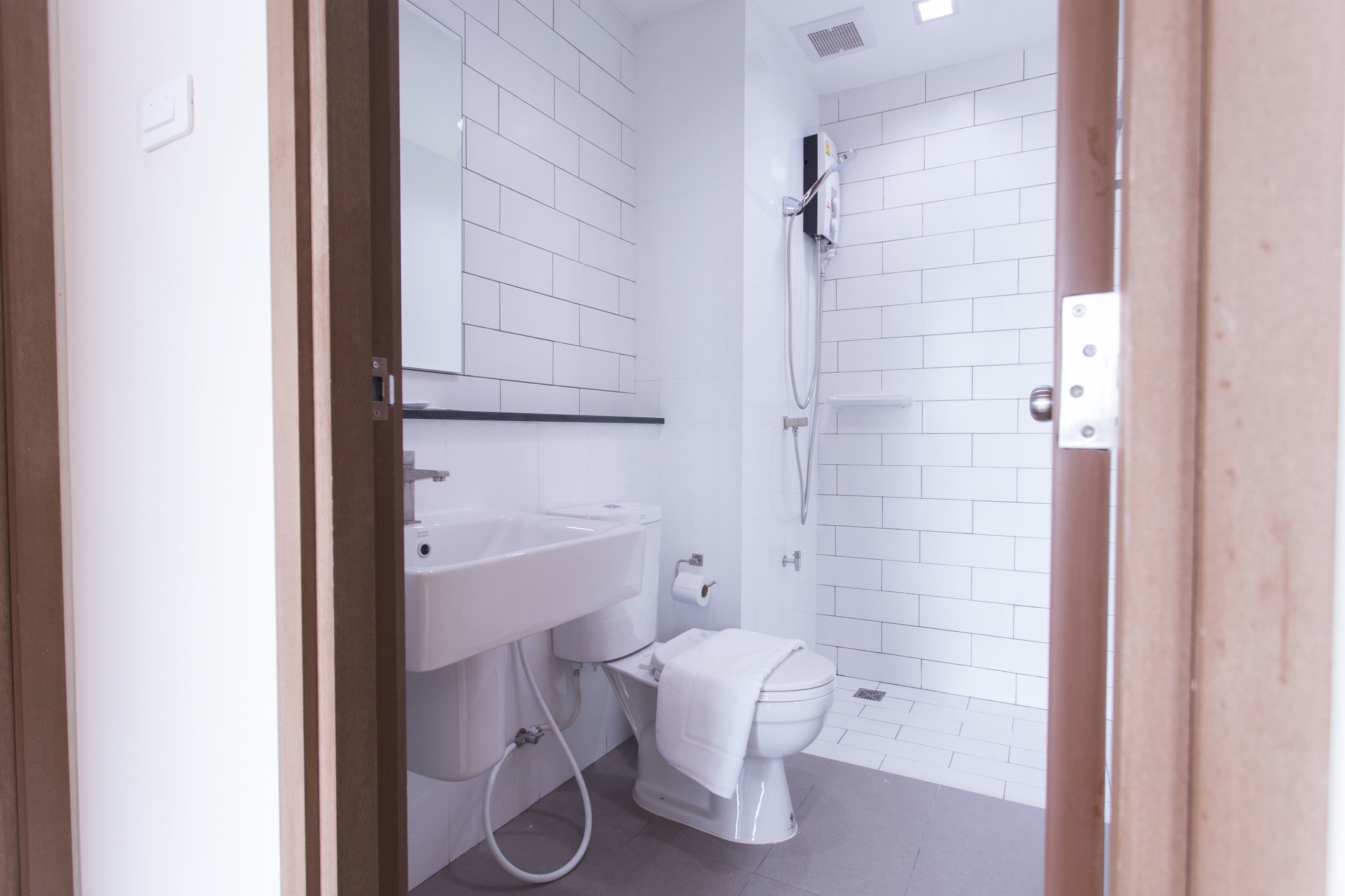 A bathroom with a white sink, toilet, and shower.