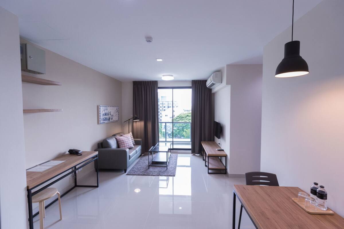Una sala moderna con sofá, mesa de centro y zona de comedor.