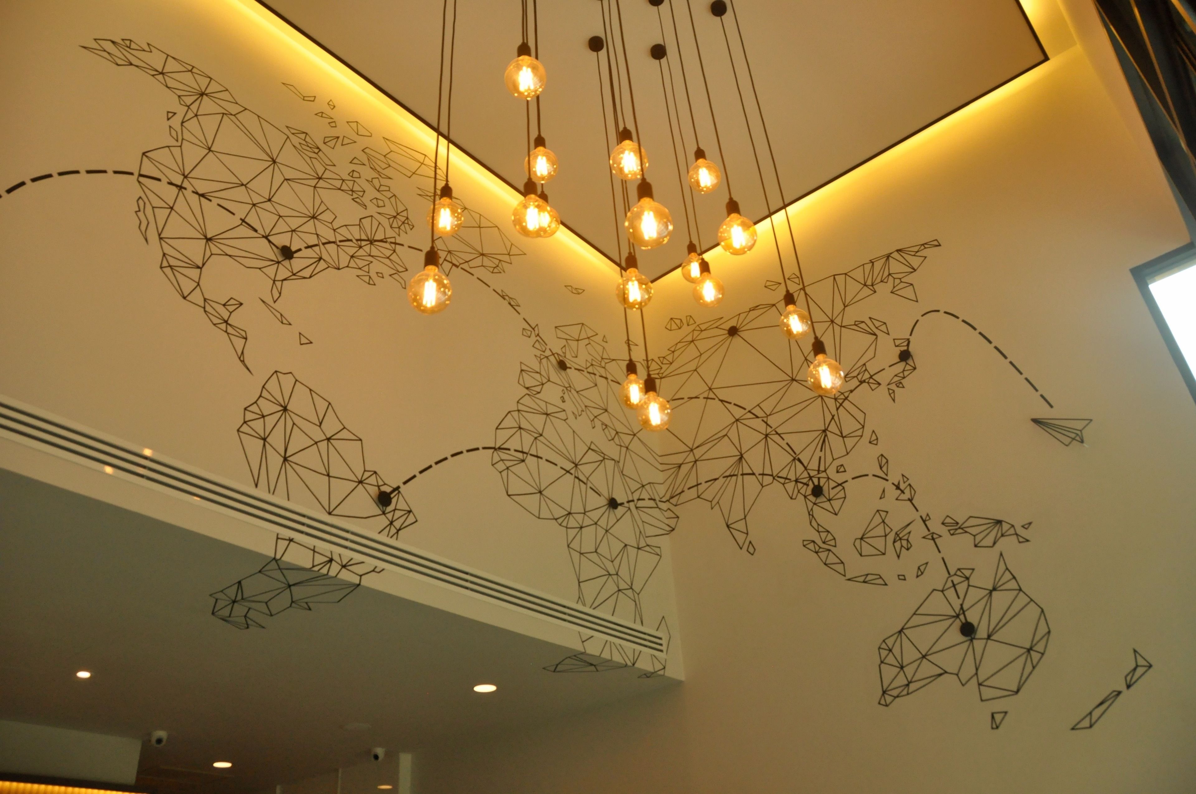 A modern interior with a geometric wall design and hanging light fixtures.
