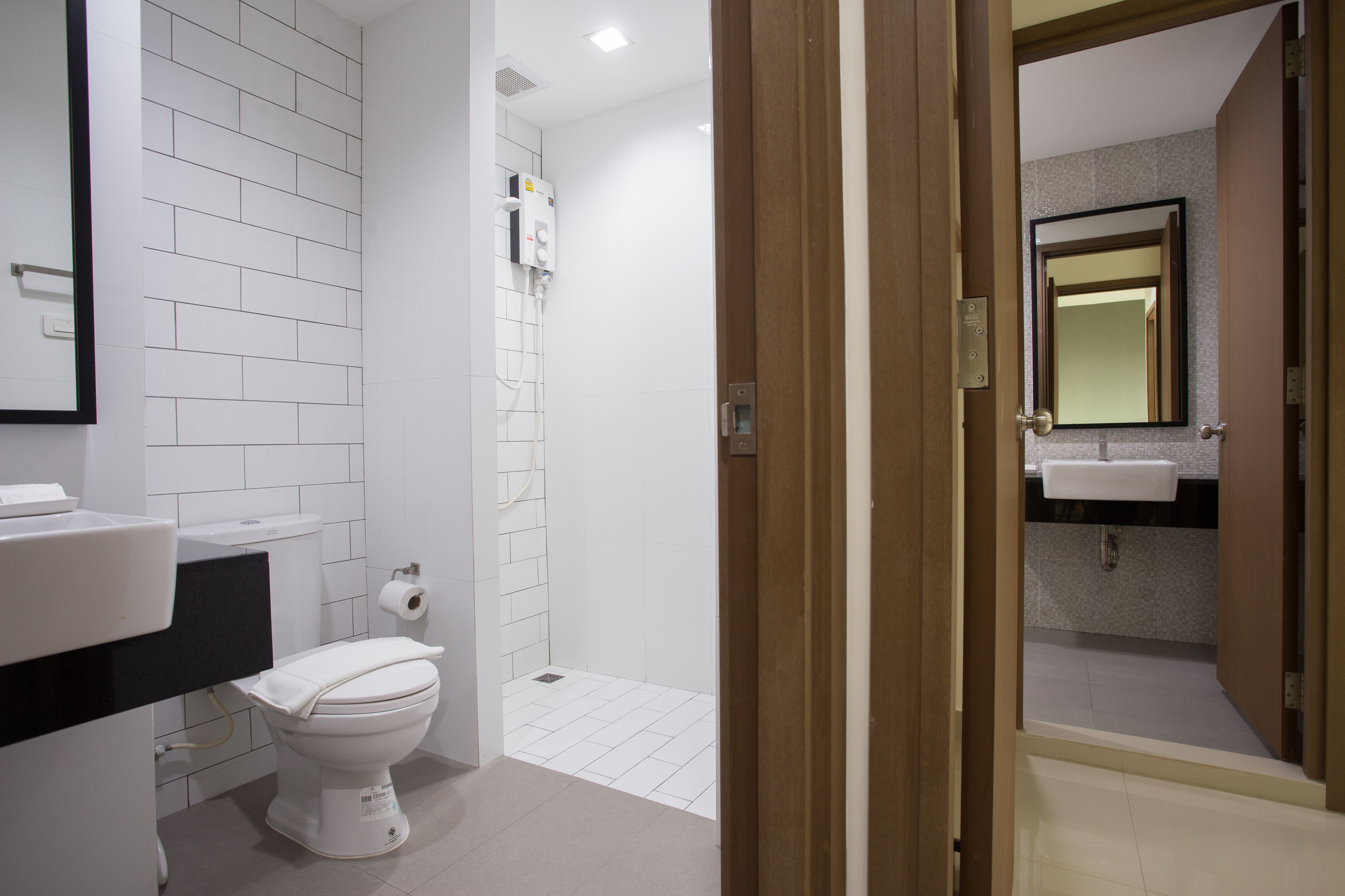 Un baño moderno con inodoro, lavamanos y zona de ducha.
