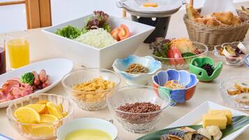 A table with various food items, including fruits, vegetables, and dishes, suggesting a meal setting.