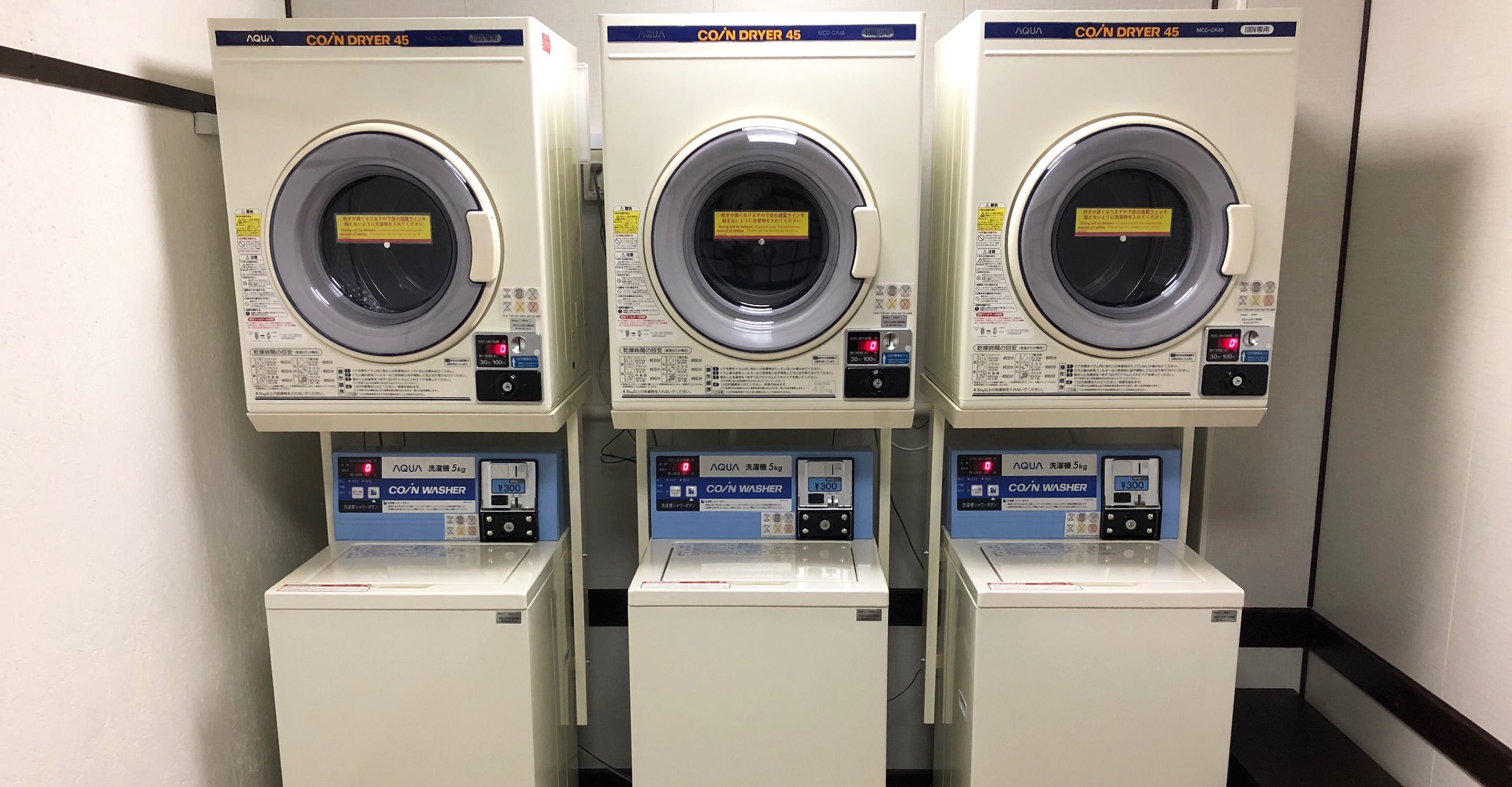 Three identical coiled dryers with control panels, labeled 'AQUA CO/N DRYER 45' and 'CO/N WASHER', each with a capacity of 5kg.