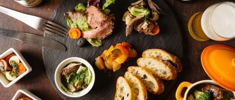 A dining table with a variety of dishes including meat, vegetables, and bread.